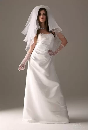 Сексуальная невеста снимает свадебное платье во время эротической фотосессии